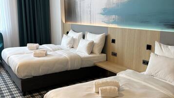 A hotel room with two beds, a large abstract painting on the wall, and a checkered floor.