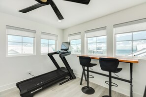 Ein modernes Zimmer mit Laufband, Schreibtisch und zwei Stühlen.