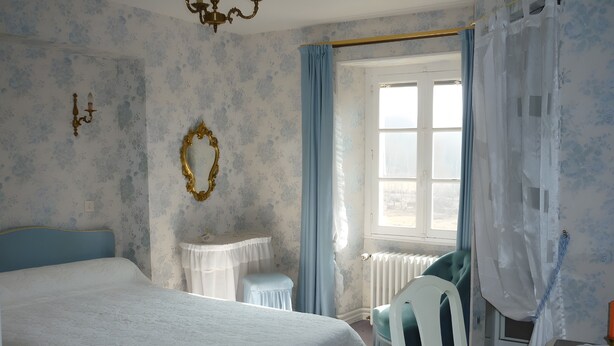 A bedroom with a large bed, a bedside table, a chair, a window with curtains, and a wall-mounted mirror. - Bed and Breakfast 'Domaine Des Mouillères - Julie' with Shared Terrace, Shared Garden and Wi-Fi (Saint-Georges-la-Pouge)
