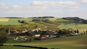 A rural landscape with rolling hills, a small village, and a church.