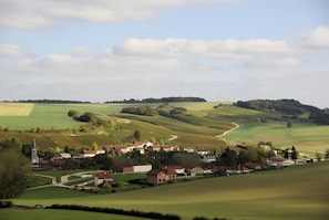A rural landscape with rolling hills, a small village, and a church.