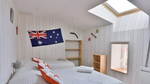 Un dormitori amb un lucern, una bandera i un llit amb un edredó estampat.
