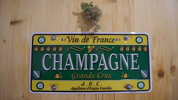 Een houten wand met een decoratief bord waarop 'CHAMPAGNE' en de tekst 'Vin de France' staan.