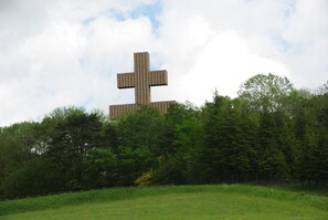 A large wooden cross structure in a grassy field with trees in the foreground. - Room 'Chambre Champagne' with Shared Garden and Wi-Fi (Rizaucourt-Buchey)