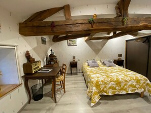 Une chambre à coucher avec un lit, un bureau, une chaise, une armoire et une fenêtre.