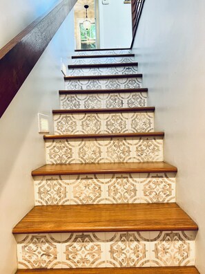 Un escalier avec des carreaux décoratifs et des marches en bois.