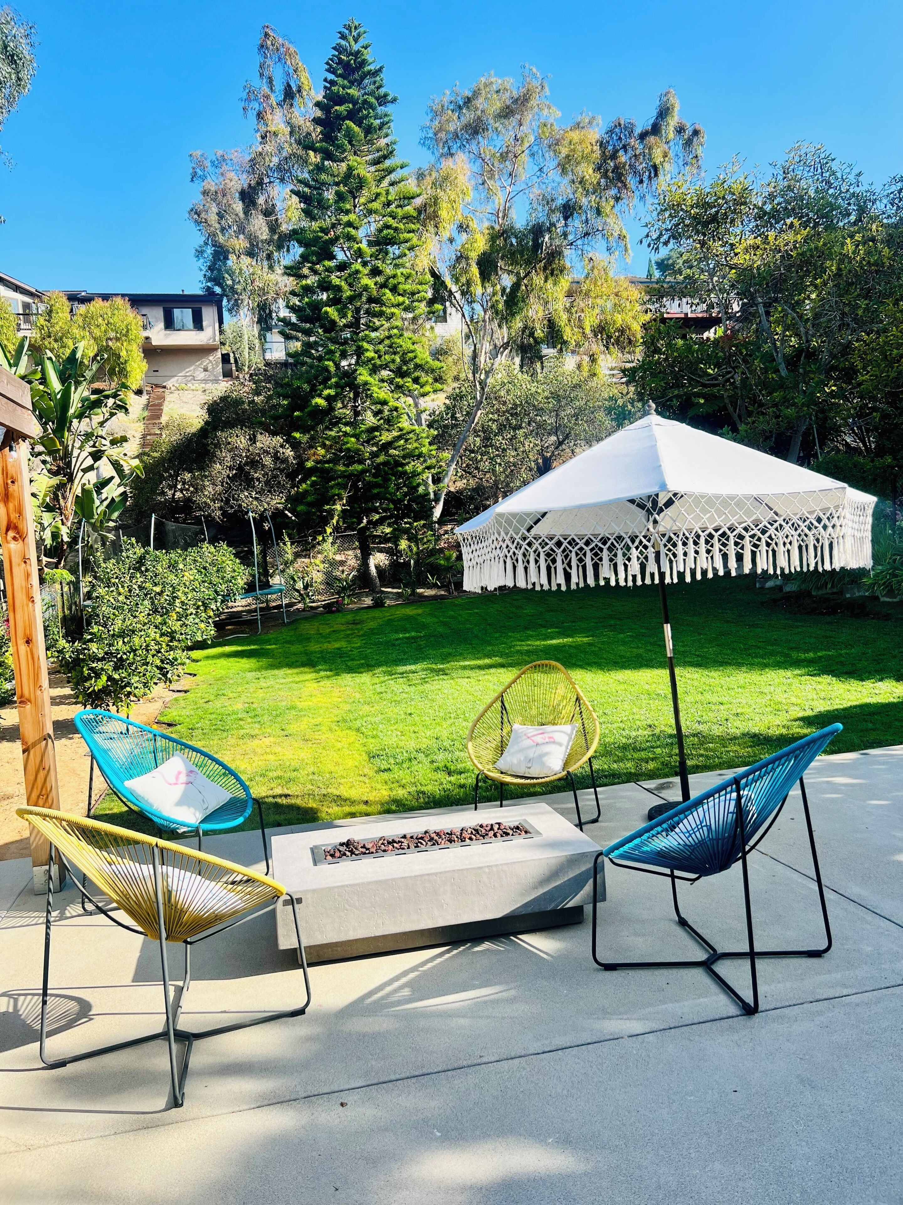 A patio area with outdoor seating, a white canopy, and a well-maintained lawn.