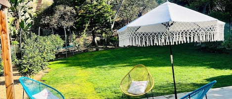 A patio area with outdoor seating, a white canopy, and a well-maintained lawn.