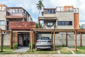 Ein modernes Gebäude mit einem hölzernen Eingangsbereich, ein Auto vor der Fassade und ein Schild mit der Aufschrift 'Lani Beach Villas'.