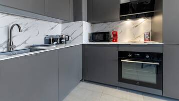 A modern kitchen with a built-in microwave, coffee maker, and oven.