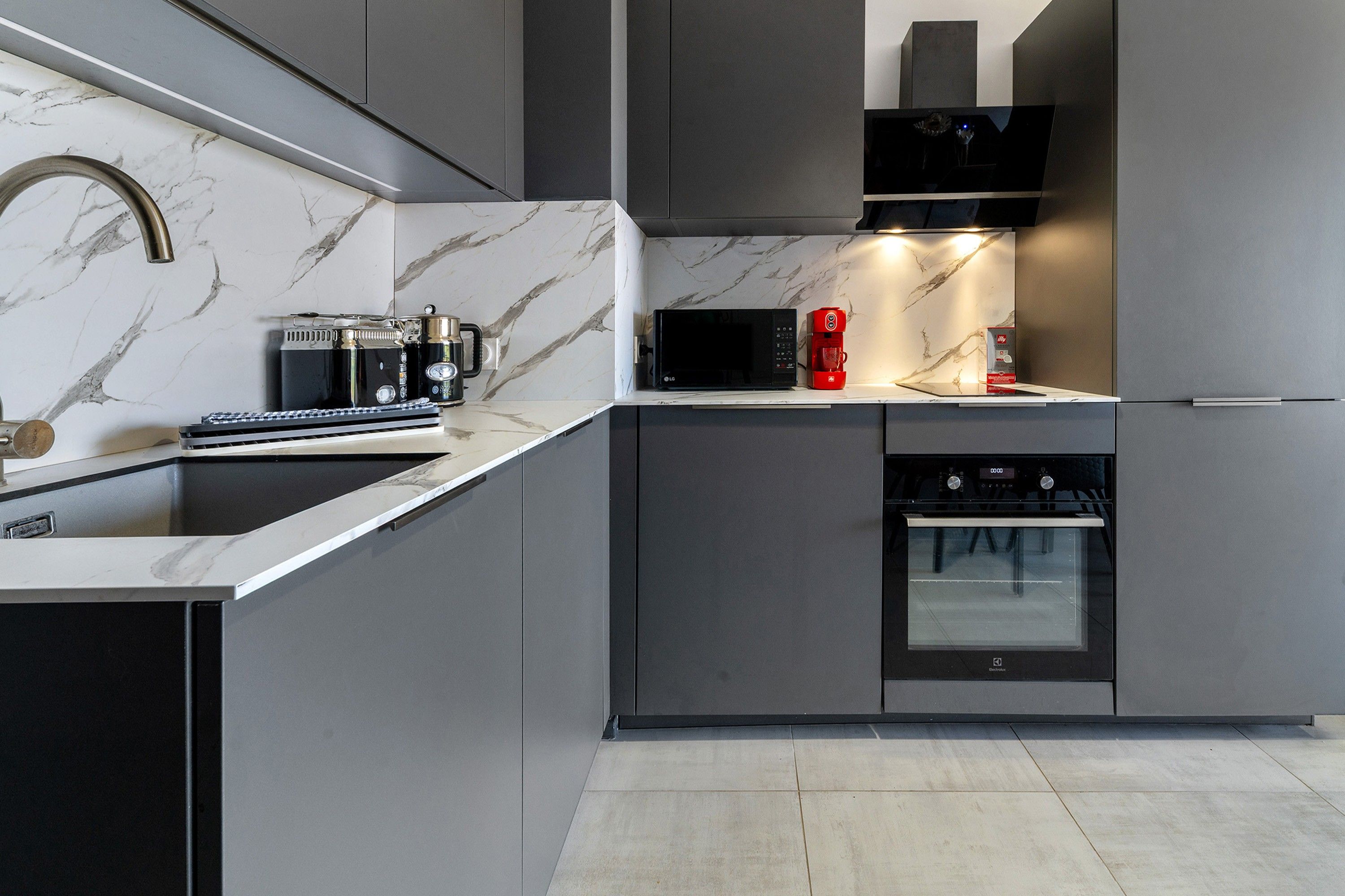 Una cucina moderna con forno a microonde, macchina del caffè e forno.