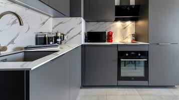 Una cucina moderna con forno a microonde, macchina del caffè e forno.