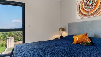 Una camera da letto con un letto grande, un comodino, una lampada e un quadro appeso al muro.