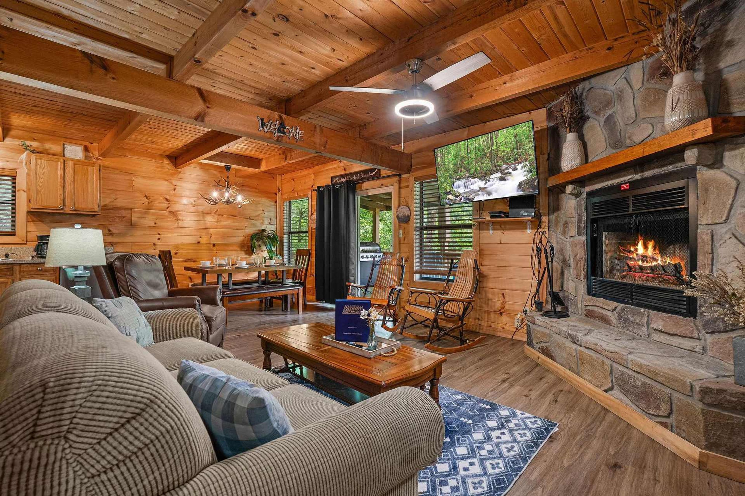 L’intérieur d’un chalet confortable, avec une cheminée, des meubles en bois et un coin repas.