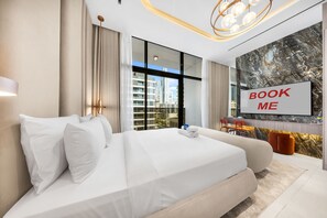 Ein modernes Hotelzimmer mit einem großen Bett, einem Schreibtisch und einem an der Wand befestigten Fernseher.