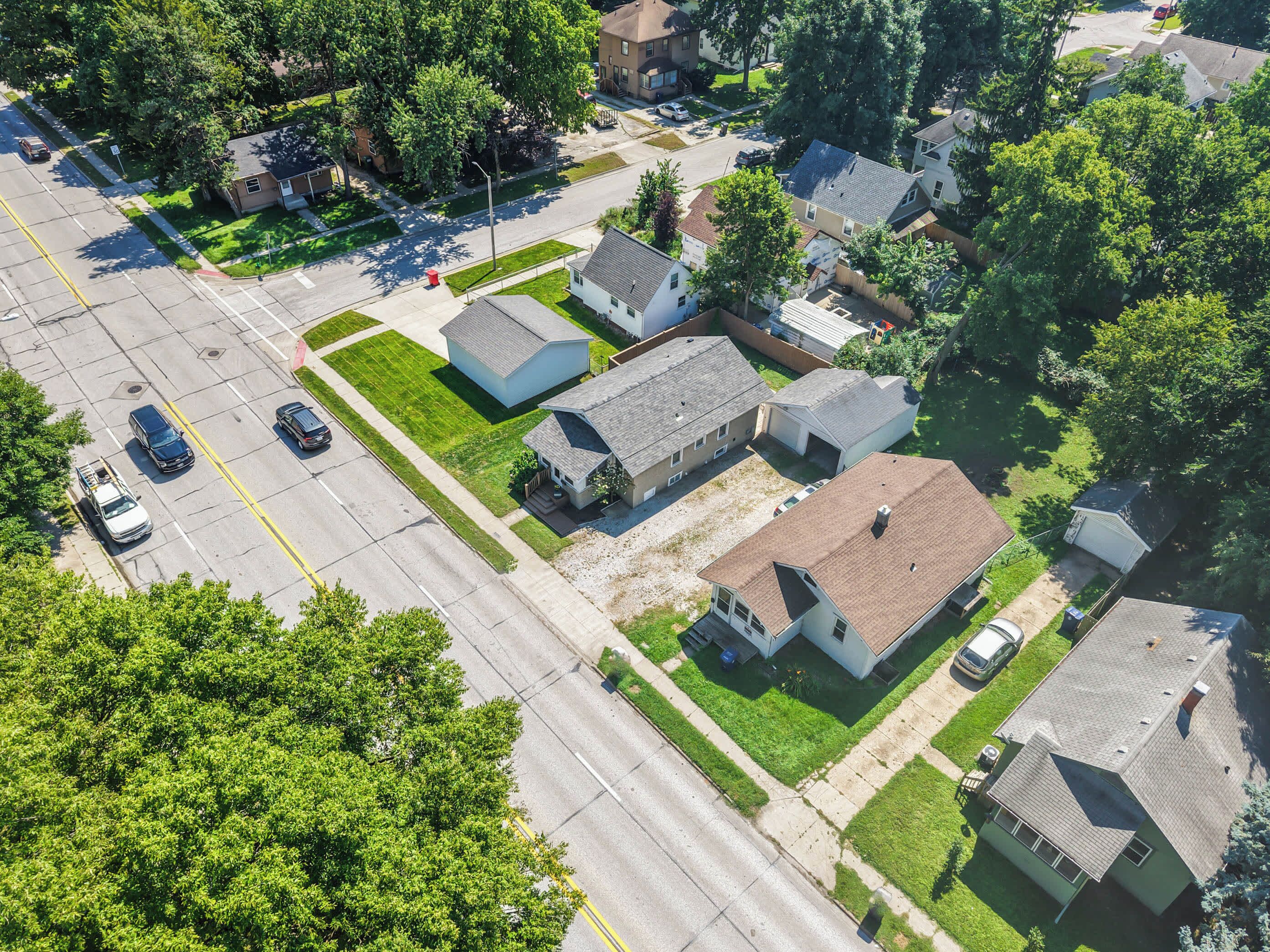 Vue aérienne d’un quartier résidentiel avec des maisons, un parking et une route.