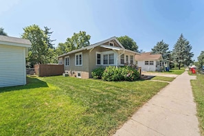 A residential area with houses, a sidewalk, and a grassy lawn. - Sleeps 7,  2BR-2BA | 5 mins walk to ISU (Ames)