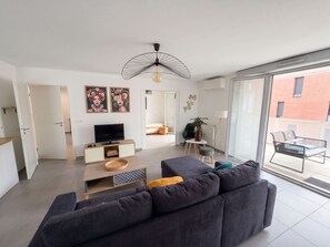 A modern living room with a sofa, TV, and artwork. - L Azulejo - Work From Home Ideal - Mobility Lease Rental - 4pax (Toulouse)
