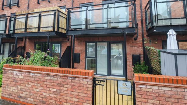 A multi-story residential building with a brick facade, large windows, and a gated entrance. - Blanket Row (Hull)