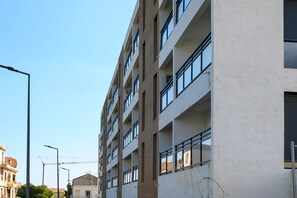A multi-story building with a modern architectural style, featuring balconies and large windows.