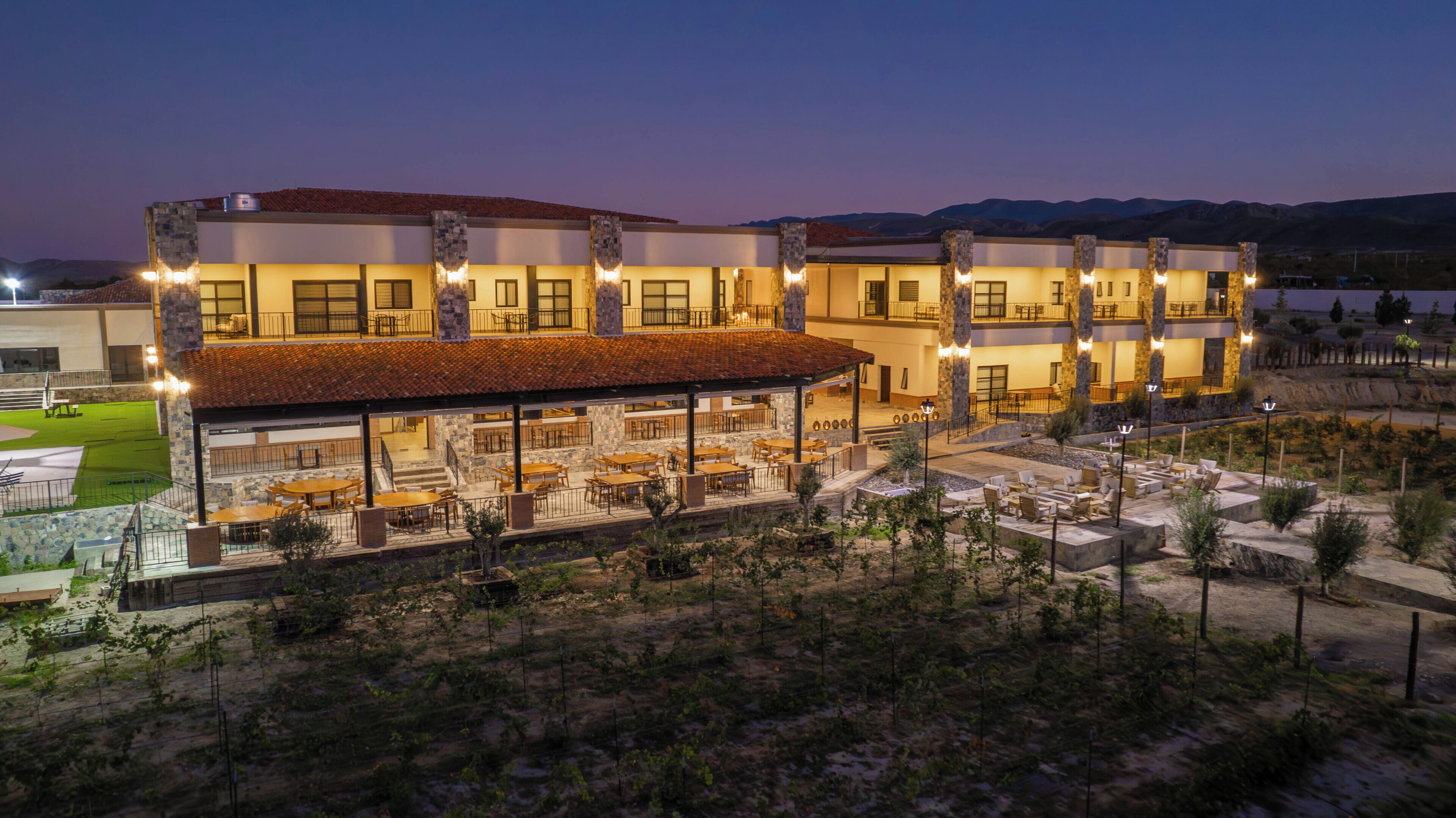 Un hotel de varios pisos con asientos exteriores y un patio cubierto.