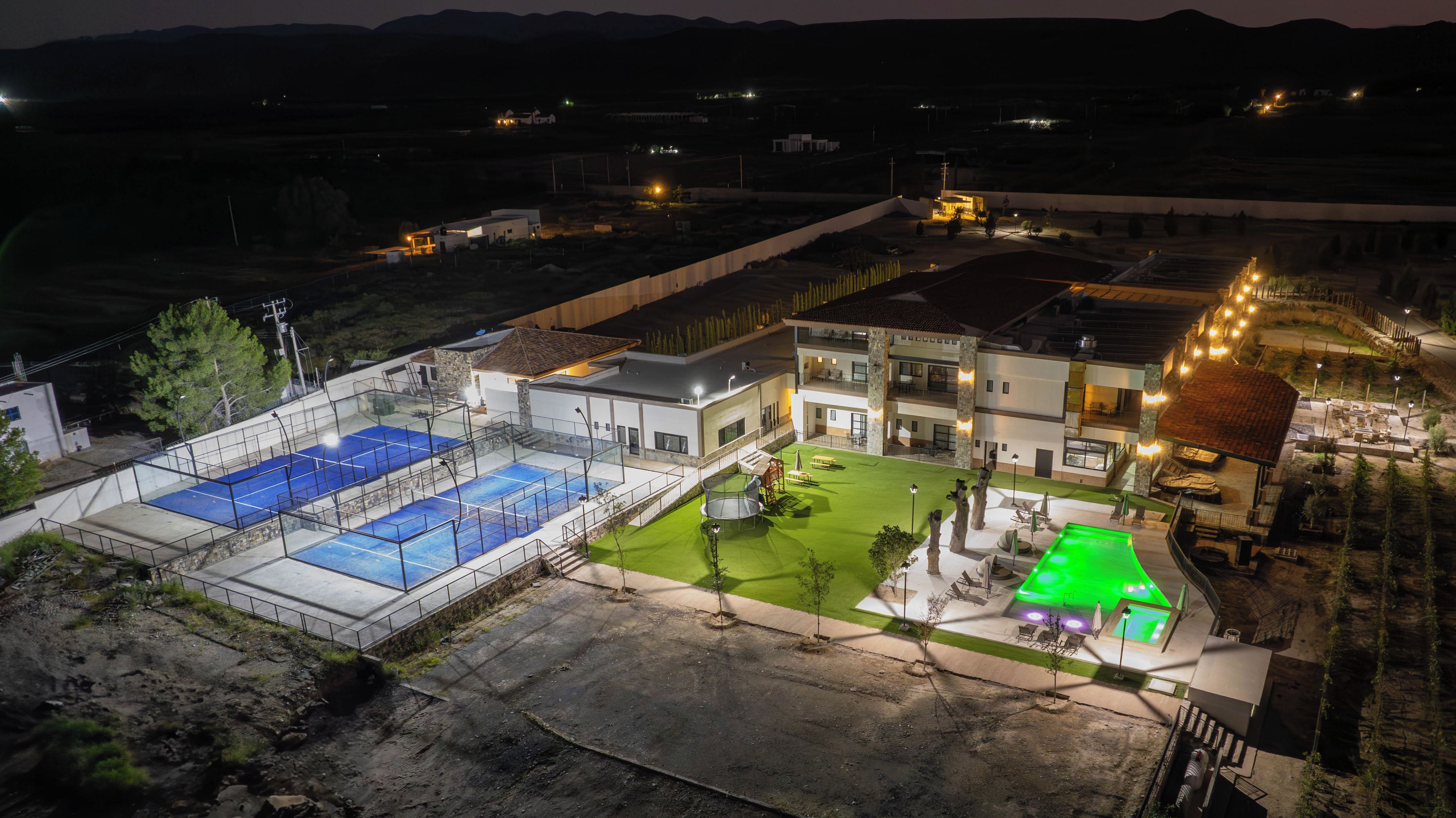 A residential property with a swimming pool, a tennis court, and a landscaped garden.