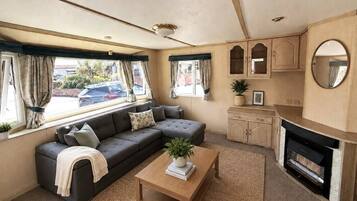 A cozy living area with a sofa, a coffee table, and a fireplace.