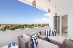 A balcony with wicker furniture and a view of the city.