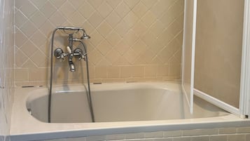 A bathroom with a bathtub, a shower, and a toilet.