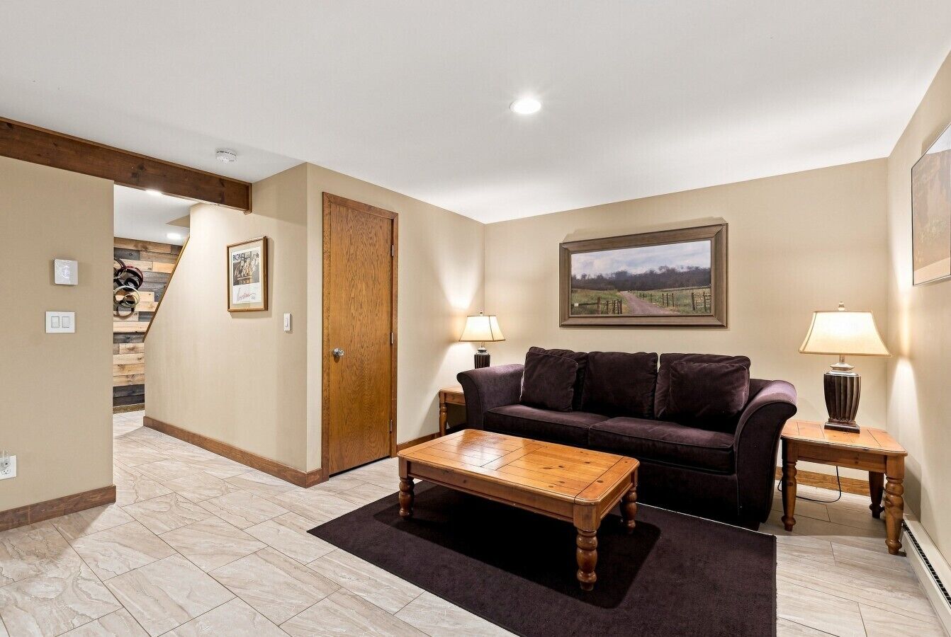 A living room with a wooden coffee table, a dark-colored sofa, and two lamps on side tables.