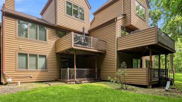 A multi-story house with a balcony and a covered porch.