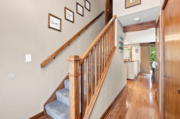 A staircase with wooden railings and a carpeted landing.