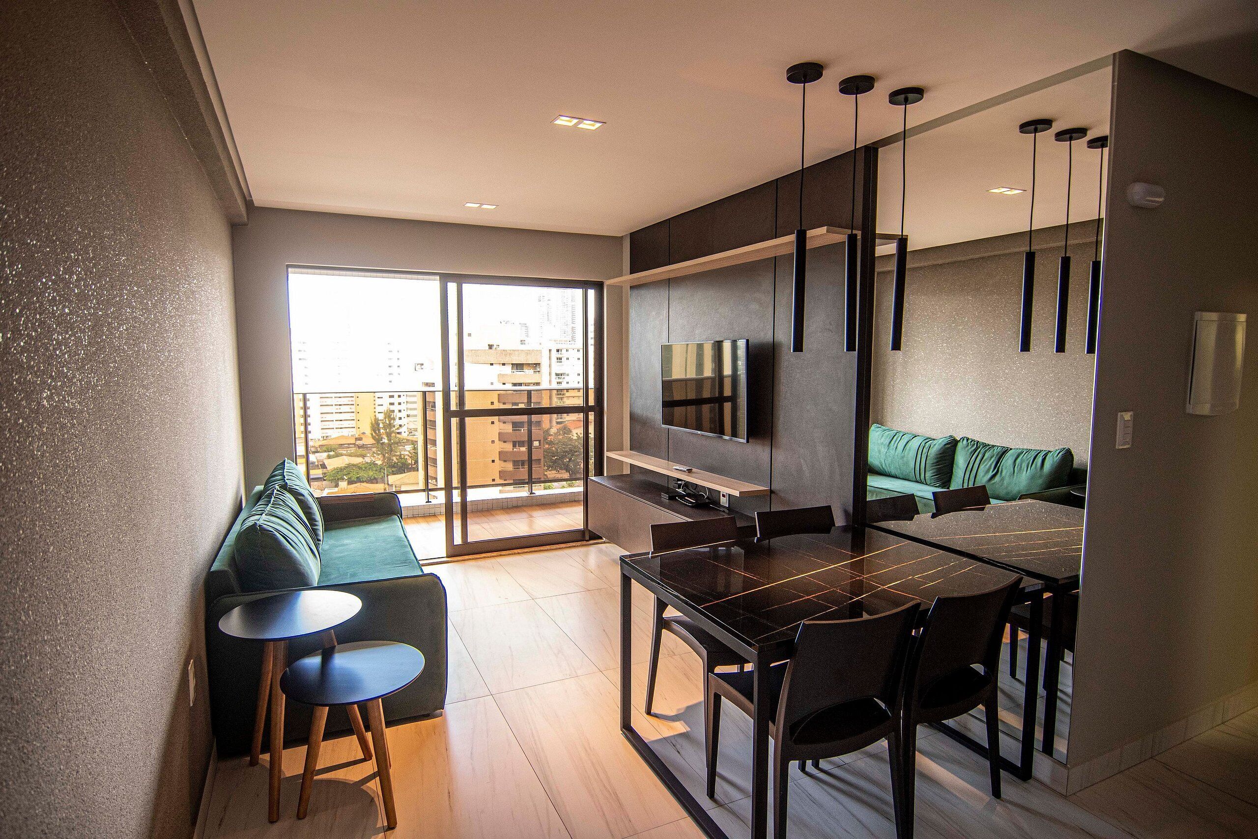 A modern kitchen with a dining area, large windows, and a view of the city.