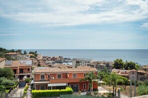 A coastal residential area with terracotta-roofed houses, a marina, and a clear view of the sea. - GuestHost - BaiAmare - Attic with Pool & Parking (Capo Mulini)