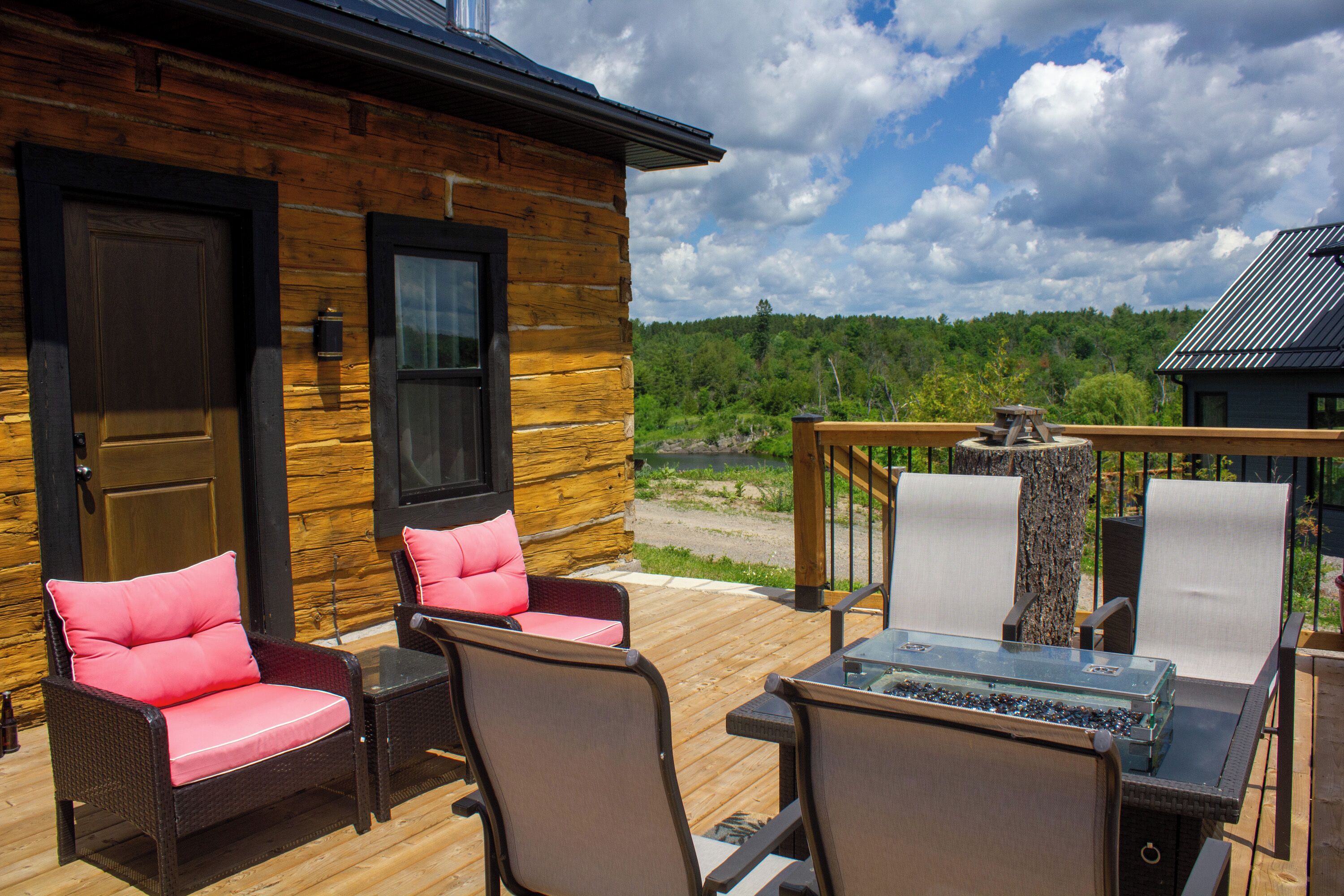 Eine Holzdiele mit Terrasse, ausgestattet mit Korbstühlen und einem Tisch mit Glasplatte.