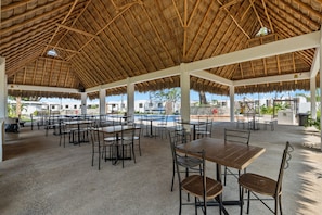 An outdoor dining area with thatched roofs, tables, and chairs. - Aldea Hortus Retreat for 21 with Jacuzzi (Tondoroque)