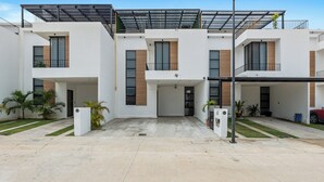 Un edificio residencial moderno de varios pisos con entrada cubierta y cochera.