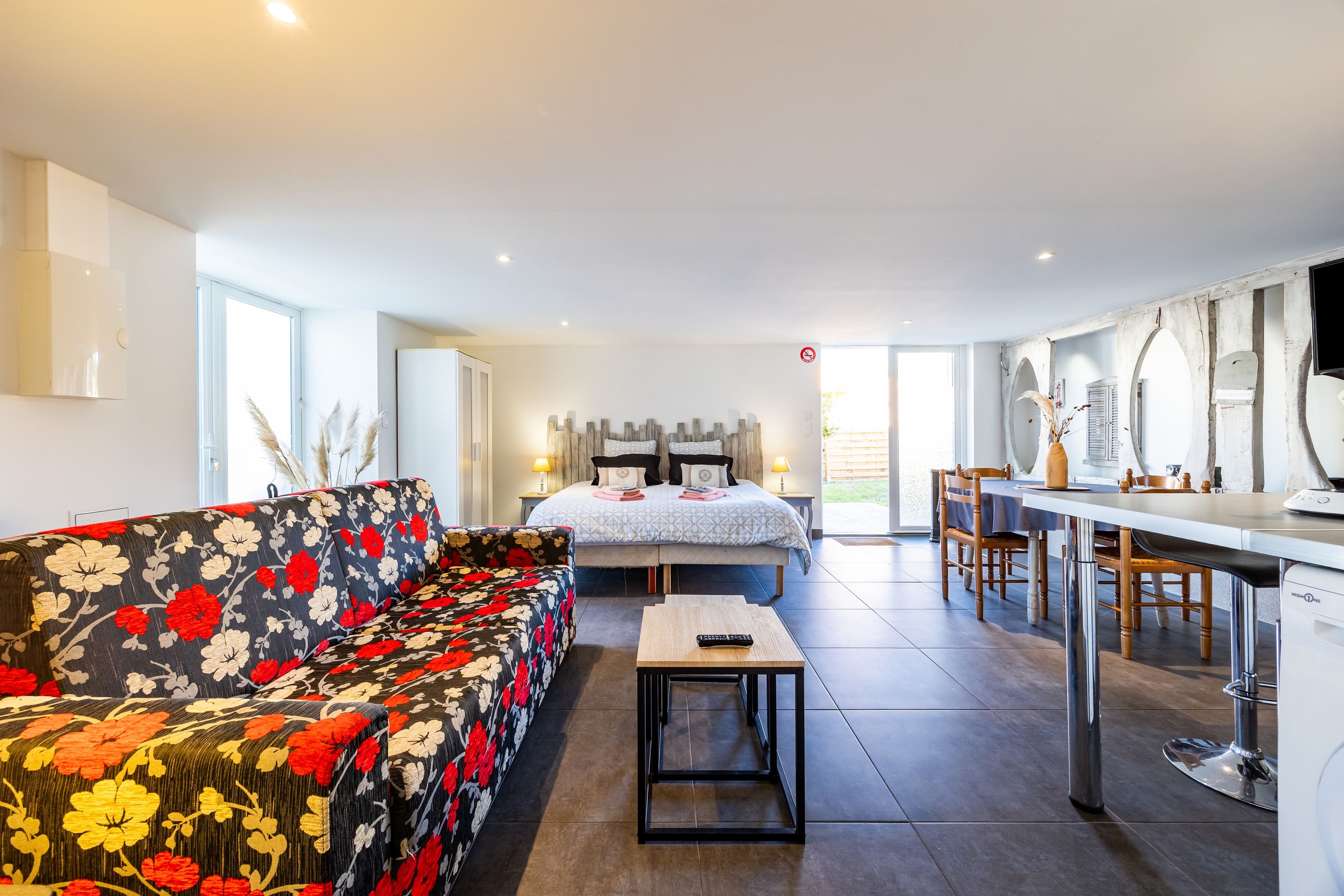 Una habitación de hotel moderna con cama, sofá, comedor y cocina.
