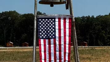 A flagpole with an American flag and a bell.