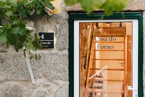 Ein Gebäudeeingang mit einem Schild, auf dem 'Casa do Forno' steht und die Hausnummer '4' angegeben ist.