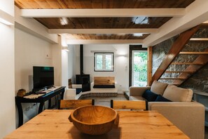 Ein modernes Wohnzimmer mit einem Holzesstisch, einem Fernseher und einem Kamin.