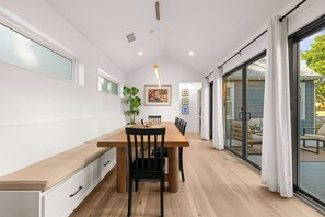 A modern dining area with a wooden table, black chairs, and a plant. - Cozy Chic House Pet-Friendly  Sleeps 12 (Georgetown)