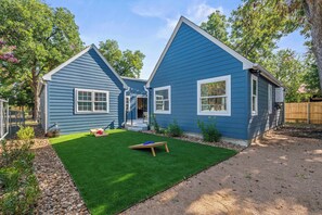 A two-story house with a well-maintained lawn and a wooden deck. - Cozy Chic House Pet-Friendly  Sleeps 12 (Georgetown)