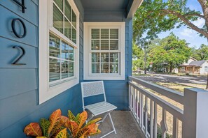 A blue house with a porch, a white chair, and a row of windows. - Cozy Chic House Pet-Friendly  Sleeps 12 (Georgetown)