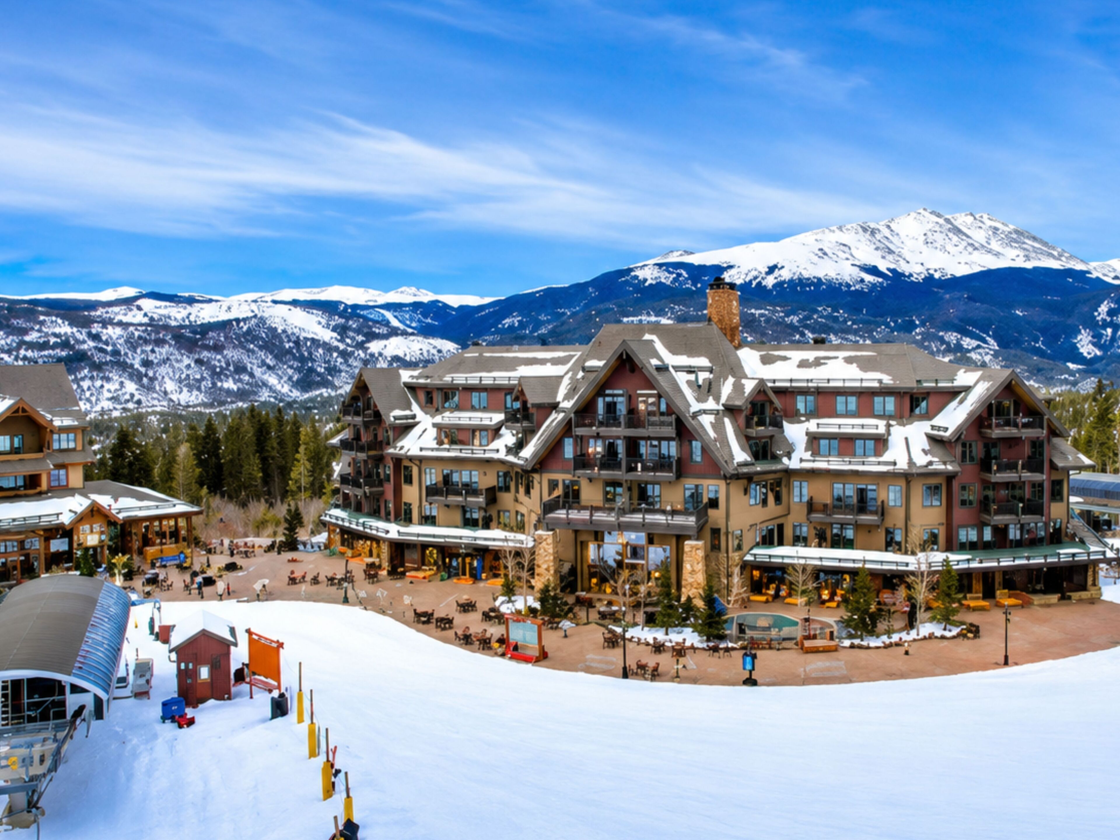 A multi-story hotel with a ski resort in the background.