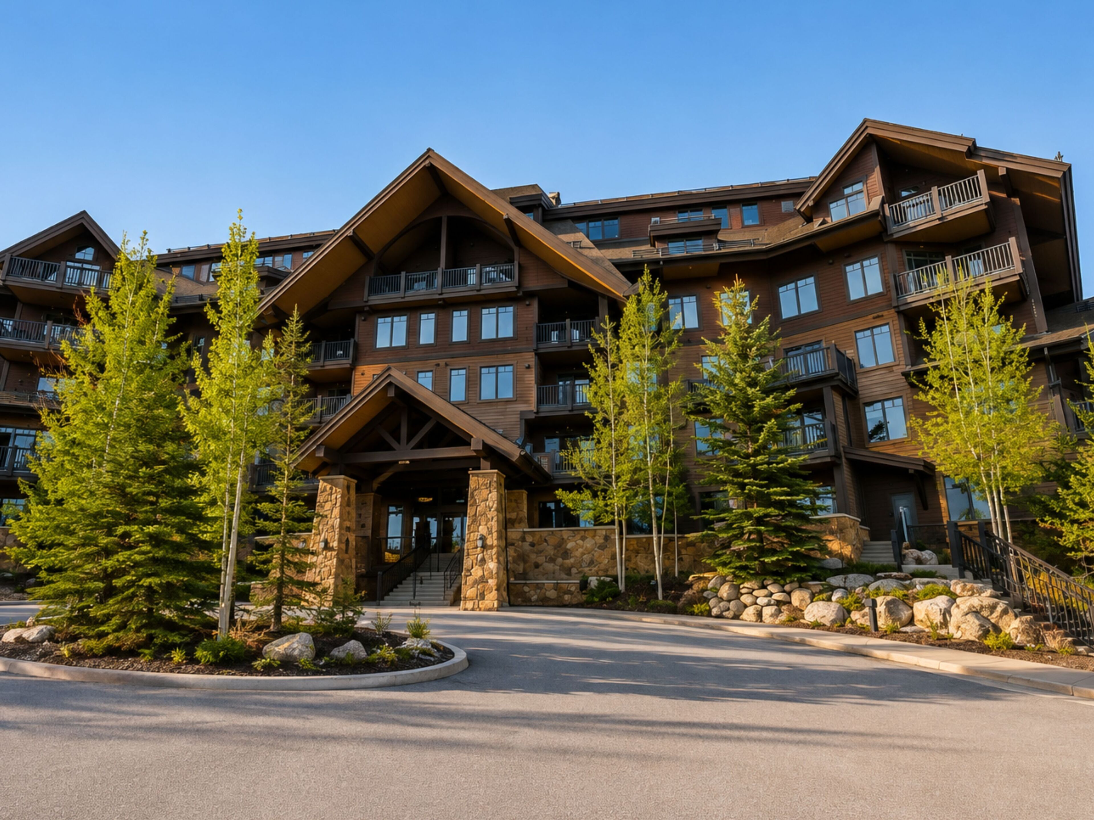 A multi-story hotel with a stone facade, balconies, and a central entrance.