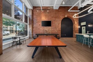 A billiards table in a room with brick walls, large windows, and a modern design. - Luxury Loft + King Bed Heart of Downtown STL (St. Louis)
