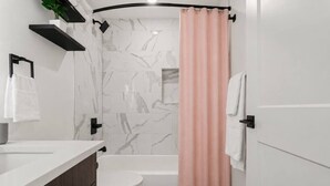 Ein modernes Badezimmer mit Toilette, Waschbecken und Duschbereich.