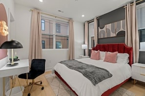 Ein modernes Schlafzimmer mit einem großen Bett, einem Schreibtisch und einem Stuhl.
