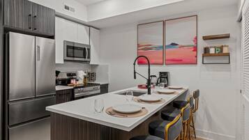 A modern kitchen with a central island, stainless steel appliances, and a minimalist design.
